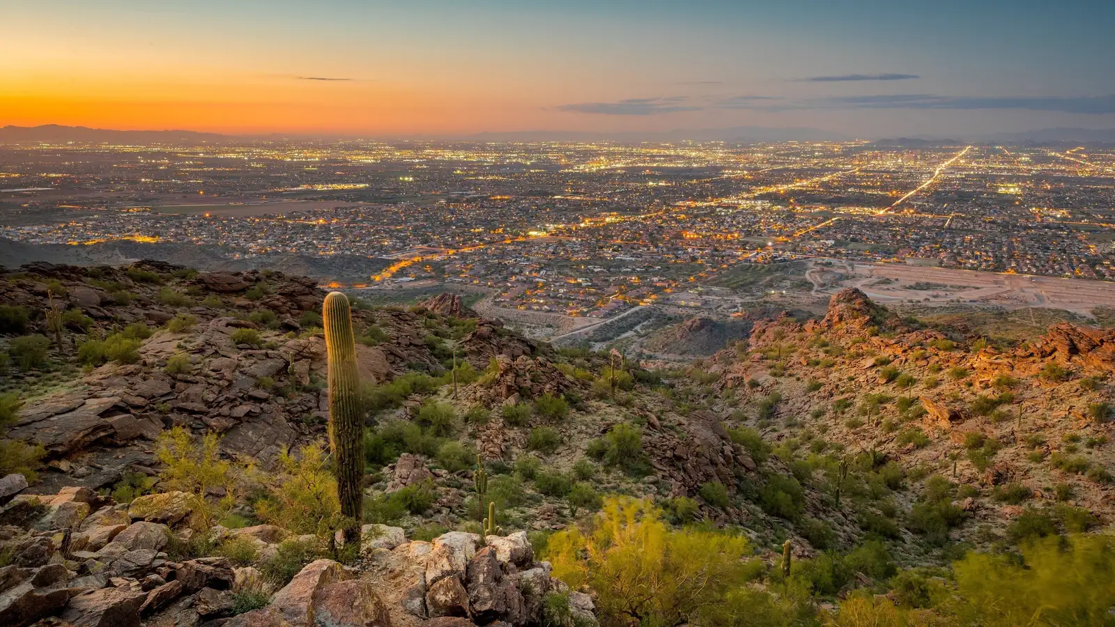 Dusk over Laveen and the Phoenix valley seen from South Mountain, city lights coming on